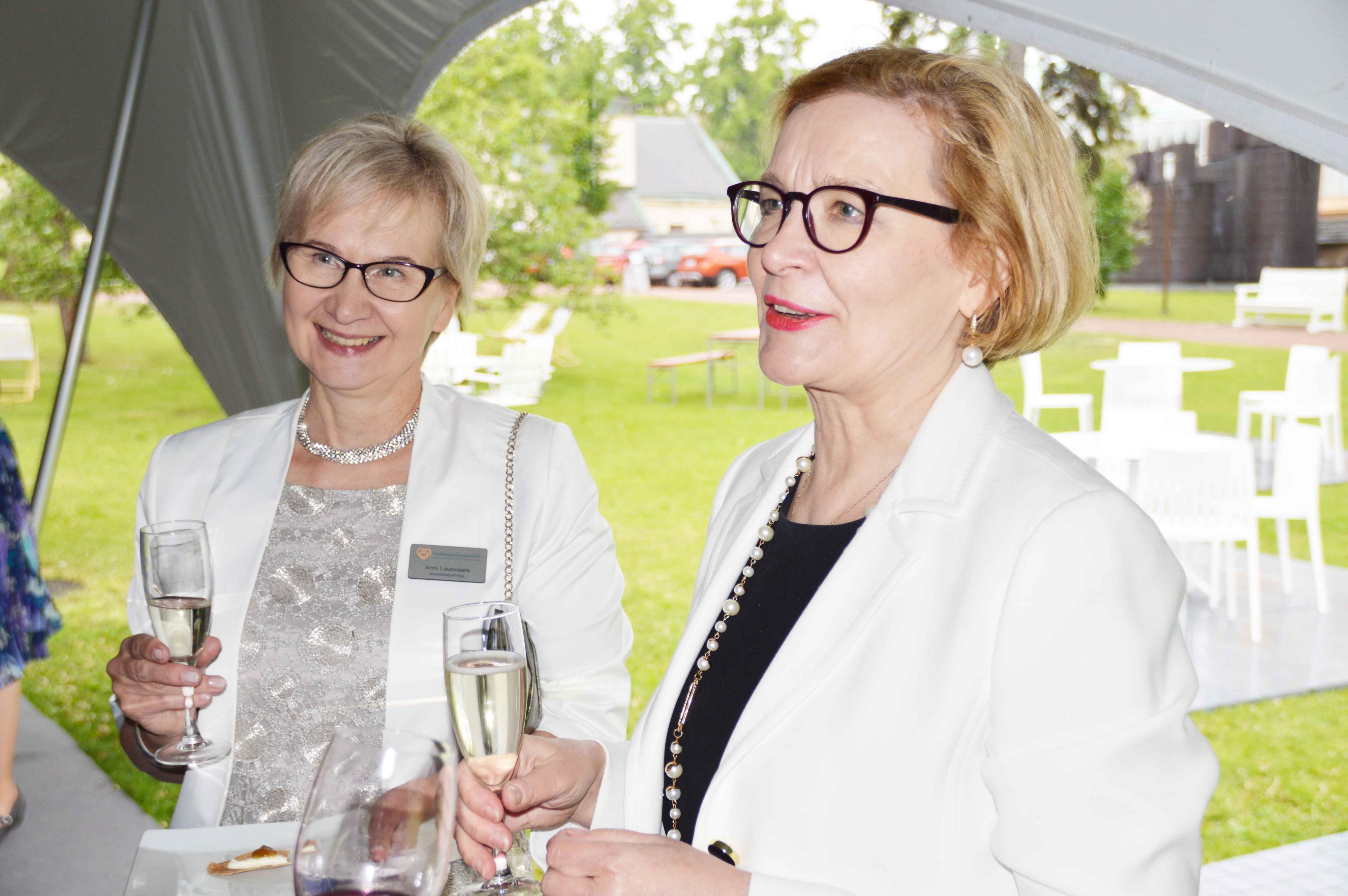 Paula Risikko ja Anni Lausvaara Vanhustyön keskusliiton 70 v-juhlissa kuohuviinilasit kädessä.