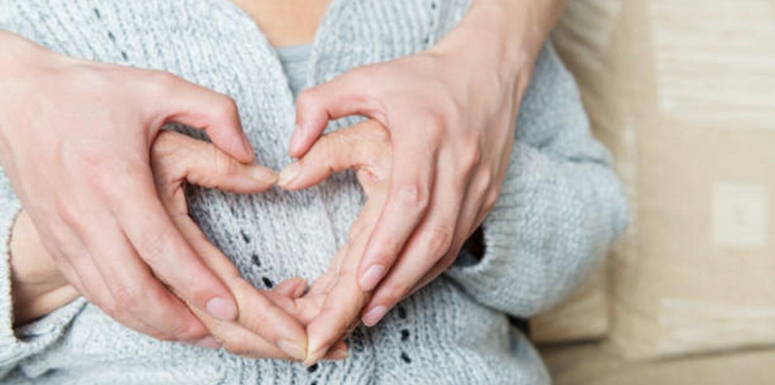 Vanhan ihmisen ja nuoremman ihmisen kädet muodostavat yhdessä sydän-kuvion.