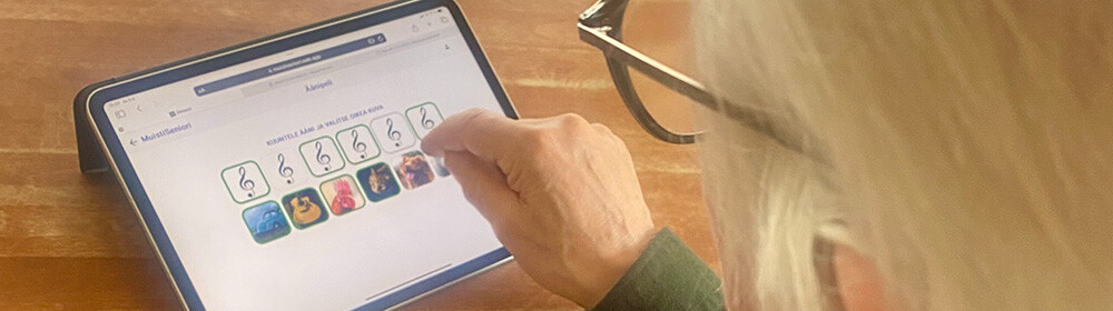 Iäkäs ihminen pelaamassa MuistiSeniori-peliä.