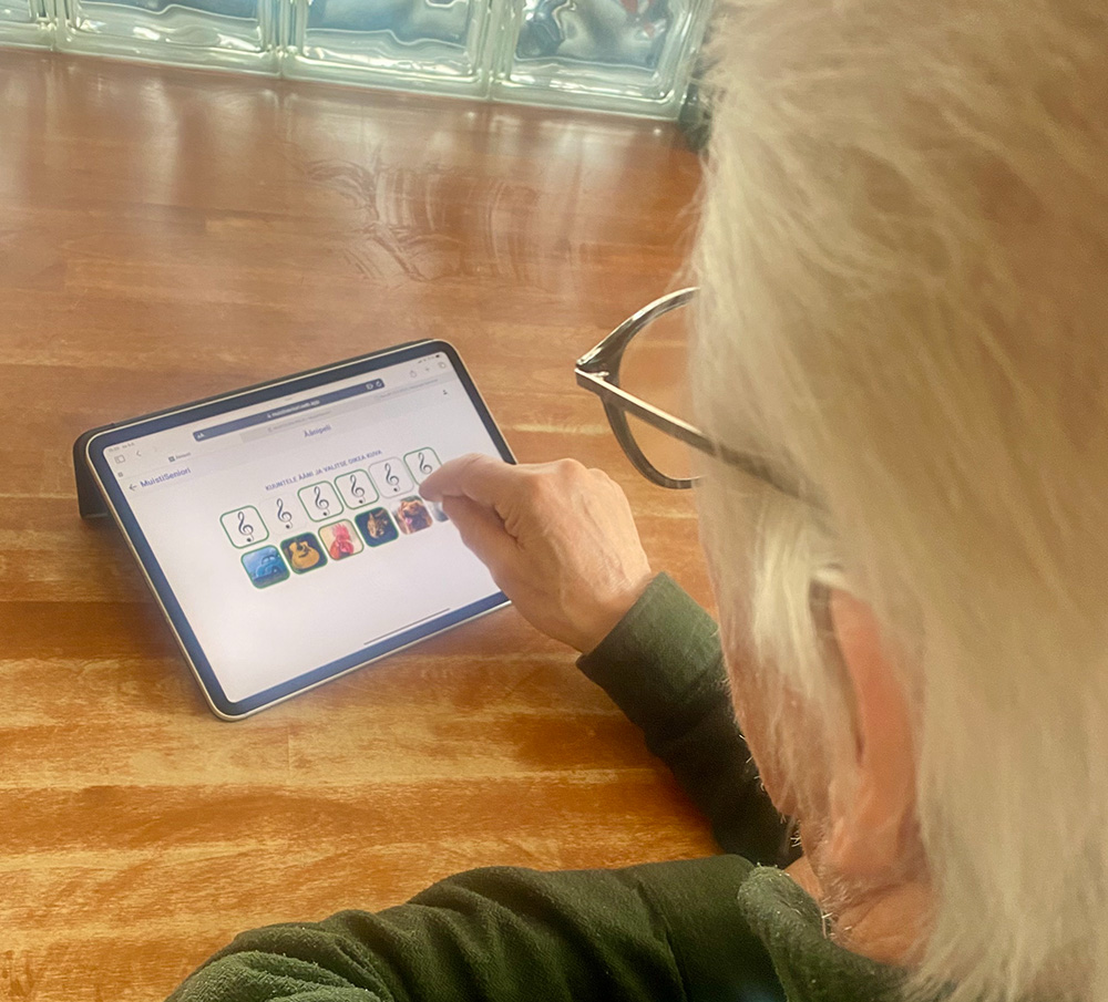 Iäkäs ihminen pelaamassa MuistiSeniori-peliä.