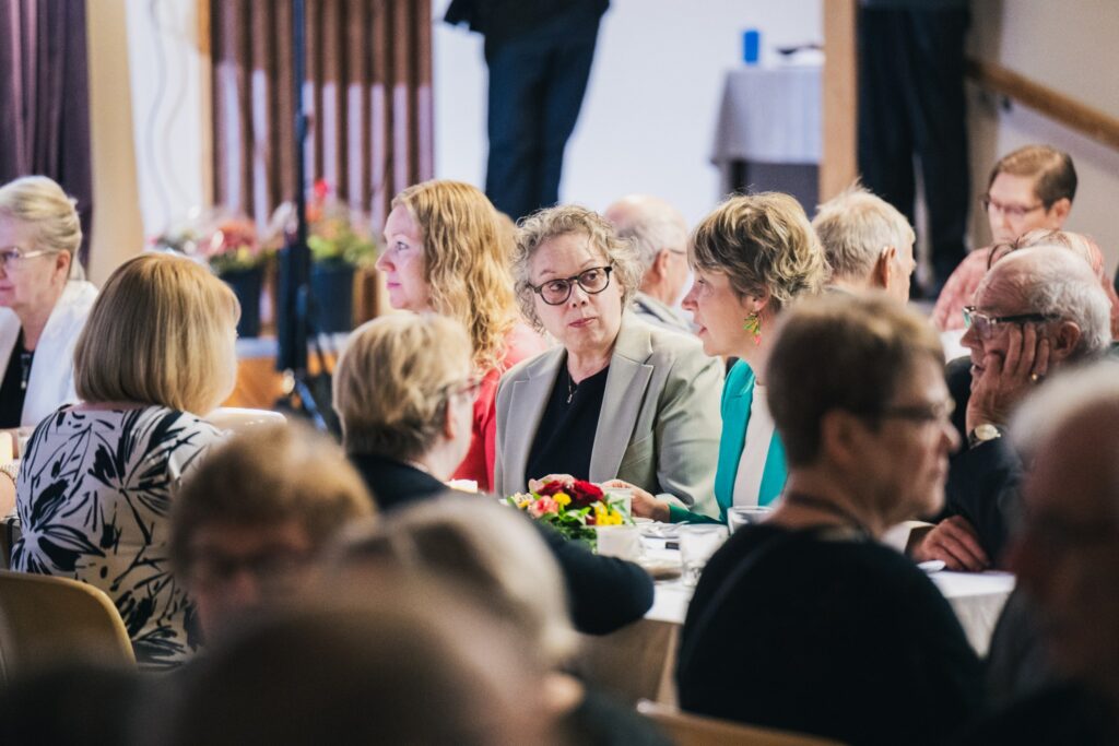 Juhlavieraat keskustelevat pöydän ääressä Pukkilan Vanhustenpäivän juhlassa.