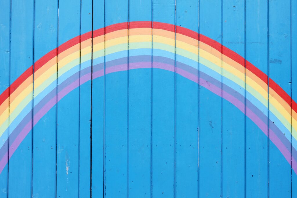 Värikäs sateenkaari maalatuna siniseen lautaseinään