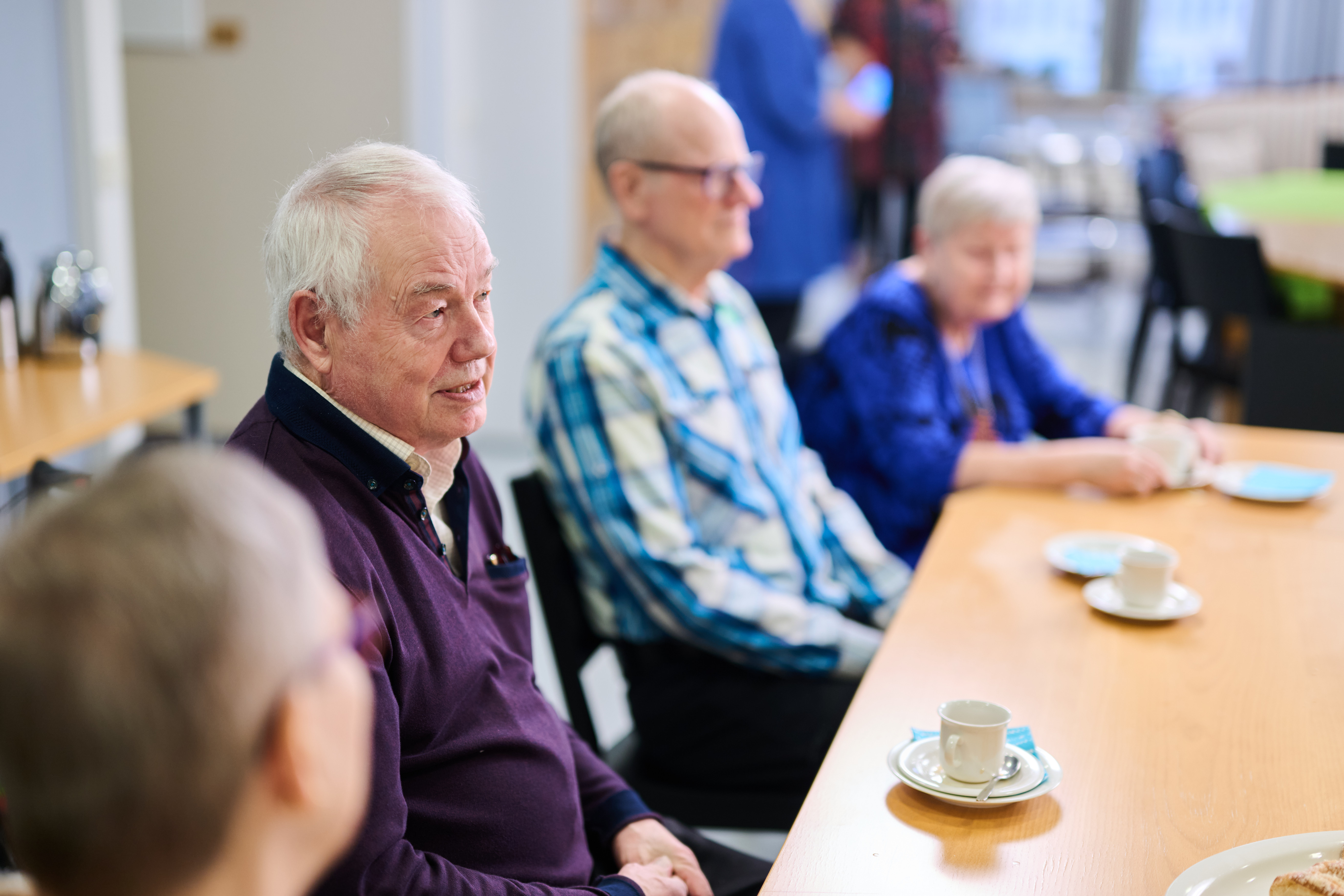 seniorit istuvat pöydän ääressä.