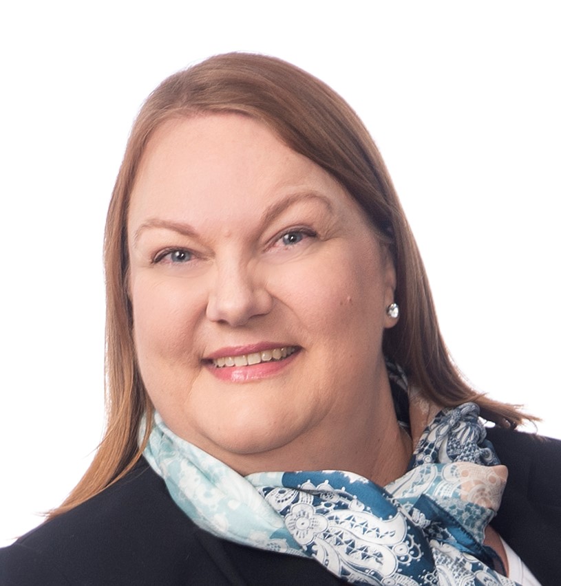 Ruskeahiuksinen nainen hymyilee kameraan. Hänellä on yllään tumma jakku ja vaalea, kuviollinen huivi kaulassa. Tausta on vaalea ja studiohenkinen.