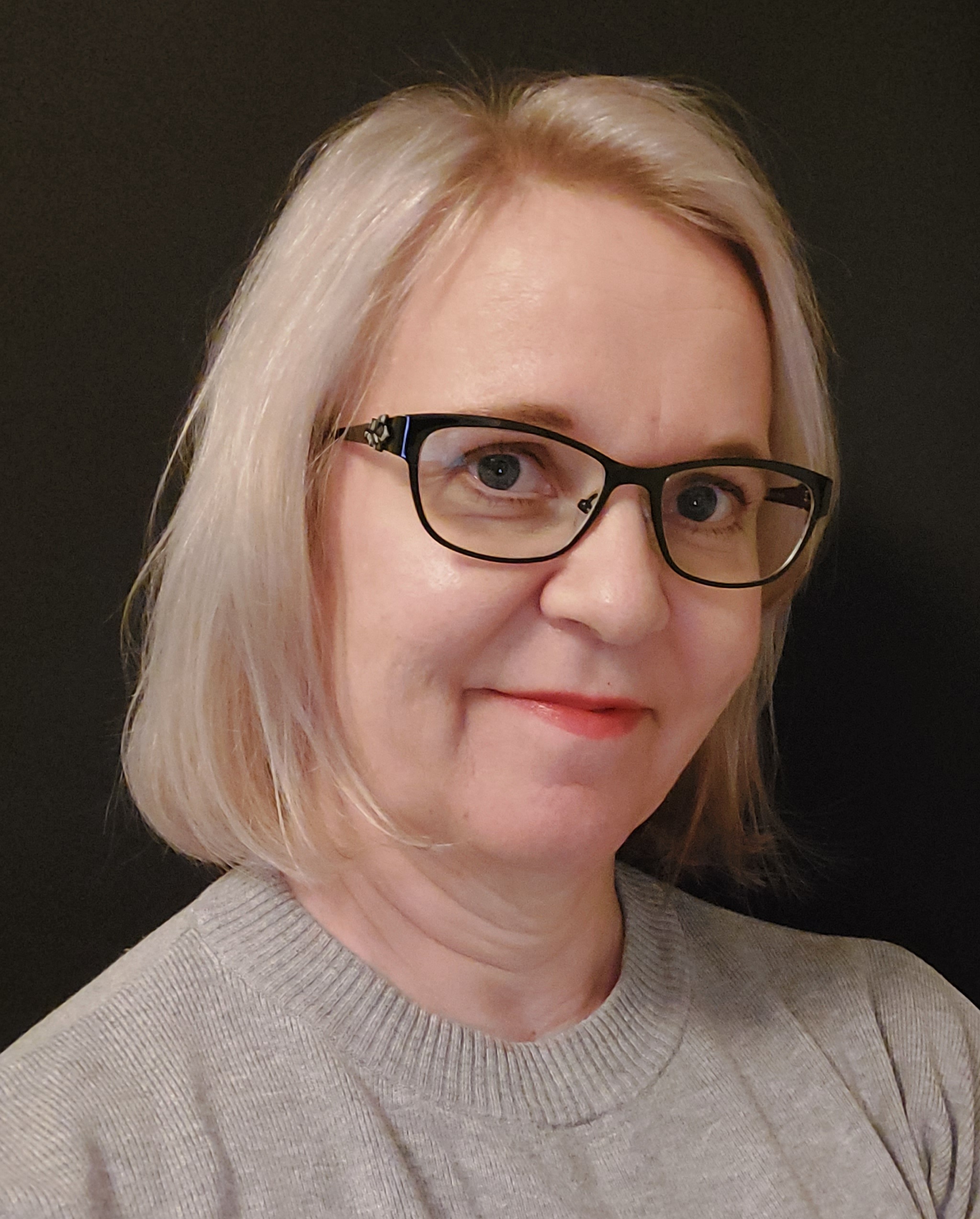 Ensimmäisessä kuvassa vaaleahiuksinen nainen, jolla on silmälasit ja harmaa paita, katsoo kameraan neutraalin taustan edessä.